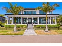 Two-story waterfront home with modern design, palm trees, and a black fence at 2926 Coffee Pot Ne Blvd, St Petersburg, FL 33704
