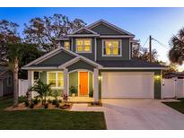 Two-story craftsman home with orange door and landscaped yard at 511 Roanoke St, Dunedin, FL 34698