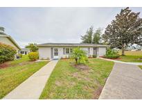 Front view of charming condo with well-manicured lawn and walkway at 302 Canton Ct # 56, Sun City Center, FL 33573
