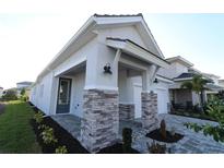 Charming single Gathering home featuring a stone columned porch with a walkway and manicured landscaping at 633 Allora Ave, Nokomis, FL 34275