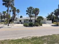 Charming single-story home with a well-maintained exterior, lush landscaping, and a spacious driveway at 909 Mandalay Ave, Clearwater Beach, FL 33767