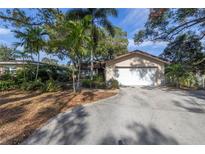 House exterior showcasing a well-maintained front yard with palm trees and landscaping at 757 50Th N Ave, St Petersburg, FL 33703