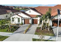 Two-car garage and landscaped front yard at 17523 Holly Well Ave, Wimauma, FL 33598