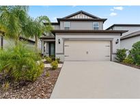 Two-story house with attached garage and landscaping at 20602 Monza Loop, Land O Lakes, FL 34638