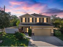 Two-story house with a neutral exterior, two-car garage, and well-manicured lawn at 8607 Tidal Breeze Dr, Riverview, FL 33569