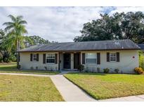 Tan house with brown roof, walkway, and landscaping at 4215 E Bay Dr # 104, Clearwater, FL 33764