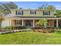 Inviting two-story home with brick facade, covered porch, and landscaped yard at 10114 Lindelaan Dr, Tampa, FL 33618