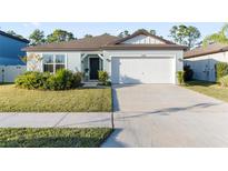 Single-story home with a two-car garage and well-manicured lawn at 30399 Marquette Ave, Wesley Chapel, FL 33545