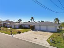 House exterior featuring a three-car garage and a large driveway at 568 Johns Pass Ave, Madeira Beach, FL 33708