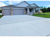 Charming single-story home featuring a spacious three-car garage and a welcoming covered entryway at 413 Shannon Estates Ct, Plant City, FL 33563