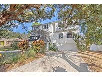 Two-story house with a screened porch and landscaped yard at 1410 Poinsettia Ave, Tarpon Springs, FL 34689