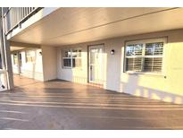 Exterior elevation of a home with a covered walkway, front door, and windows with shutters at 920 Virginia St # 204, Dunedin, FL 34698