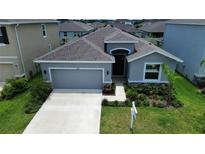Charming single-story home featuring a well-manicured lawn, attached two-car garage, and inviting front entrance at 10058 Shoreline View Way, Wesley Chapel, FL 33545