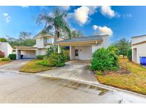 Cute 2-story house with carport, mature landscaping, and a paved driveway at 2579 Forest Run Ct, Clearwater, FL 33761