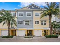 Three-story townhouses with attached garages, featuring a mix of gray and yellow siding at 3192 Nautical S Pl, St Petersburg, FL 33712