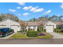 Tan two-unit building with attached garages and landscaping at 4224 Chesterfield Cir, Palm Harbor, FL 34683