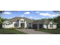 Beautiful two-story home with a three-car garage and landscaped yard at 5325 Lake Toscana Dr, Wimauma, FL 33598