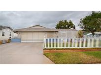 Charming single-story home with a white picket fence and landscaped yard at 6321 Staunton Dr, Holiday, FL 34690