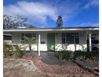 Charming single story home with a green door and well-manicured landscaping at 8153 22Nd N Ave, St Petersburg, FL 33710