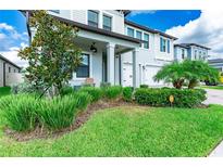 Inviting two-story home featuring a well-manicured lawn and lush landscaping at 21361 Snowy Orchid Ter, Land O Lakes, FL 34637