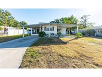 White single-wide manufactured home with carport and landscaped yard at 5212 Betmar Dr, Zephyrhills, FL 33542