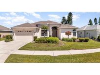 Well-maintained home featuring a manicured front lawn and inviting curb appeal at 5556 Sabal Trace Dr, North Port, FL 34287