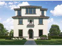 Three-story home with a light-colored exterior, arched entryway, and landscaping at 710 W Frances Ave, Tampa, FL 33602