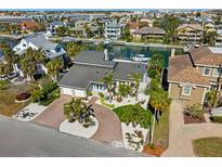 Beautifully landscaped home featuring a circular driveway and manicured lawn in a waterfront community at 123 8Th E St, Tierra Verde, FL 33715