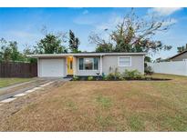 Updated single story home with a yellow door and landscaped front yard at 6524 14Th N St, St Petersburg, FL 33702