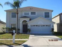 Two-story house with a two-car garage and landscaped lawn at 7423 Pulteney Dr, Zephyrhills, FL 33545