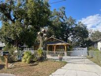 Cute yellow house with a fenced yard and driveway at 1310 E Cayuga St, Tampa, FL 33603