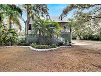 Cute cottage with a metal roof, mature landscaping, and a spacious yard at 1406 Butch Cassidy Trl, Wimauma, FL 33598