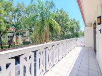 Spacious tiled balcony with decorative railings, offering serene views of the lush greenery at 2612 Pearce Dr # 304, Clearwater, FL 33764