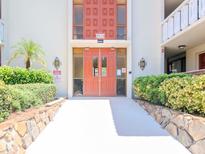 Condo building entrance with orange doors and landscaped walkway at 2612 Pearce Dr # 304, Clearwater, FL 33764