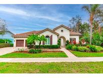 Beautiful curb appeal with a tile roof, lush landscaping, and a welcoming entryway at 5212 Candler View Dr, Lithia, FL 33547