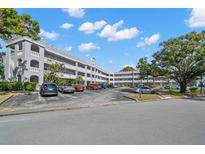 Exterior view of a multi-story condominium building with parking lot and landscaping at 2294 Swedish Dr # 4, Clearwater, FL 33763