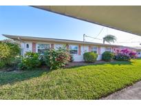 Well-maintained exterior with lush landscaping and a carport at 1901 Canterbury Ln # 19, Sun City Center, FL 33573