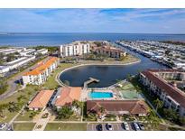 An aerial view of the community showcasing the pool, tennis court, pier, and surrounding buildings at 19029 Us Highway 19 # 25D, Clearwater, FL 33764