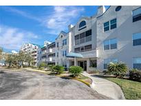 Attractive condo building exterior with lush landscaping and paved walkways at 2323 Feather Sound Dr # 310, Clearwater, FL 33762