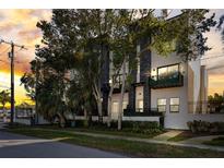 Modern three-story townhome with gray and stone exterior, plus landscaping at 4810 W Mcelroy Ave # 2, Tampa, FL 33611