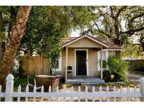 Quaint home with white picket fence, front porch, and mature trees at 8303 N Mulberry St, Tampa, FL 33604