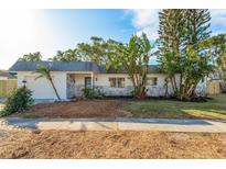 Charming single-story home with lush landscaping and a paved driveway at 12260 Eldon Dr, Largo, FL 33774