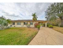 One-story home with landscaped yard, attached carport, and paved driveway at 2003 Halmrock Pl, Sun City Center, FL 33573