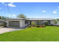 Charming single-story home featuring a well-manicured lawn and a two-car garage at 5101 Huntington Ne Cir, St Petersburg, FL 33703