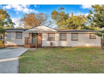 Charming single-story home with a wooden porch and landscaped yard at 7206 E 29Th Ave, Tampa, FL 33619