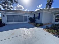 Charming single-story home with a screened garage, well-kept landscaping, and a paved driveway at 1333 Misty Greens Dr, Sun City Center, FL 33573