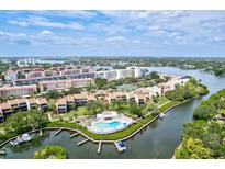Aerial view of a waterfront community with lush landscaping, a pool, and boat docks at 1700 Cove Ii Pl # 310, Sarasota, FL 34242