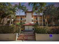 Attractive building with a fountain and lush landscaping at dusk at 2400 Feather Sound Dr # 515, Clearwater, FL 33762