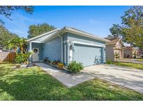 Charming blue home with attached two-car garage and landscaped front yard at 6937 Exeter Park Pl, Apollo Beach, FL 33572
