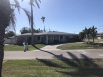 One-story home with a gray exterior, white trim, and a paved driveway at 15816 2Nd St E, Redington Beach, FL 33708